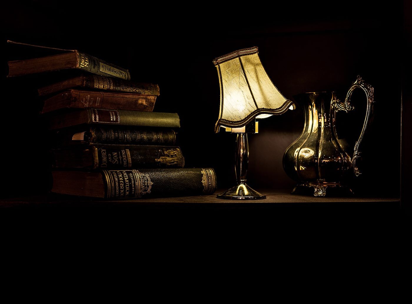 The engraving room: reference books, a working lamp, plates within reach.