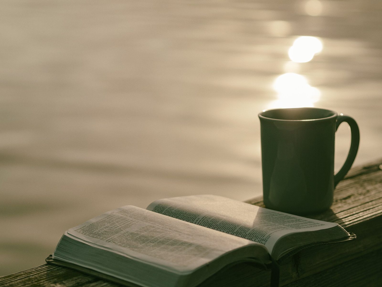A book beside a lit candle, its content only legible in the right light.