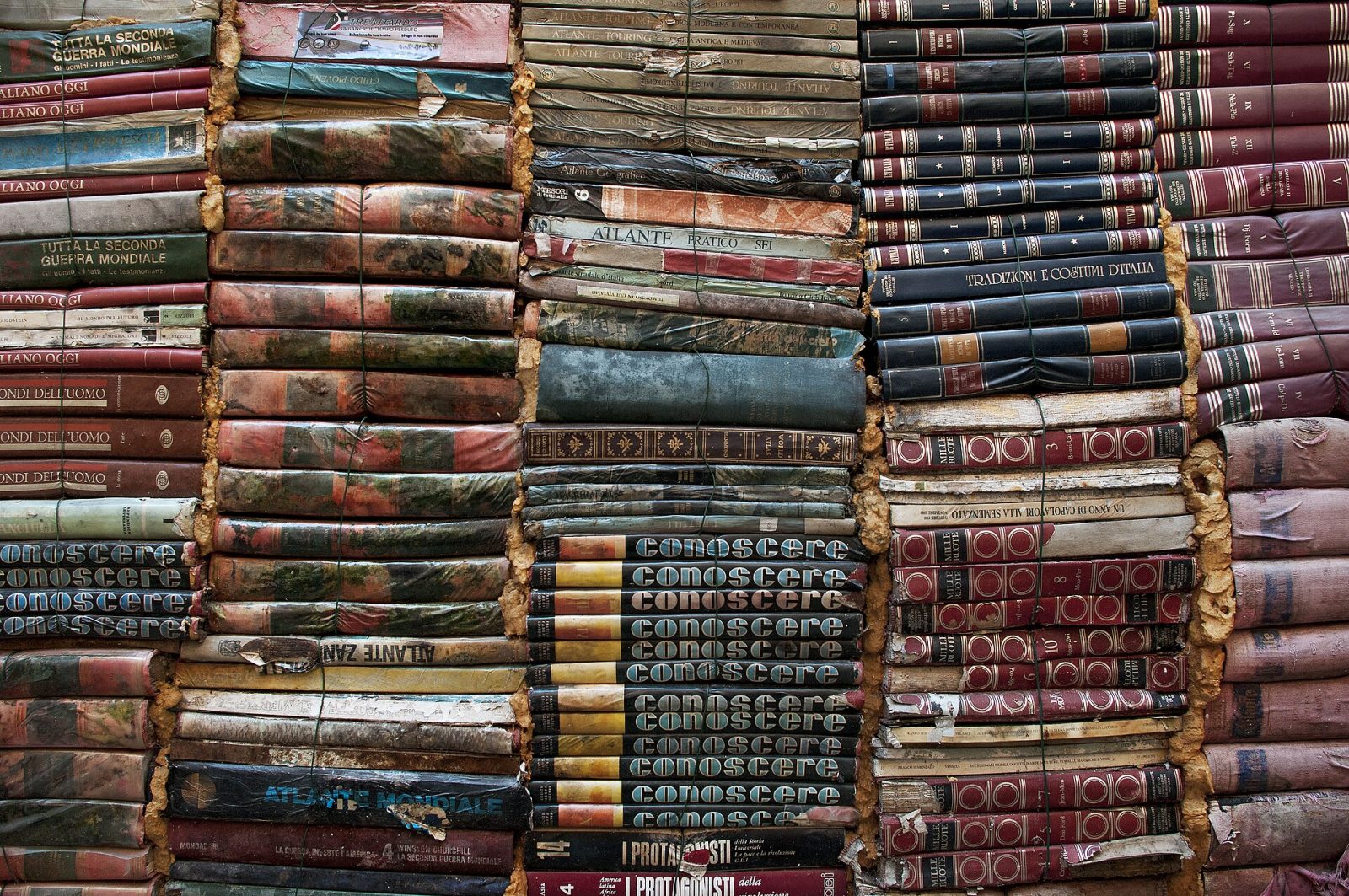 Stacks of old cloth- and leather-bound books.