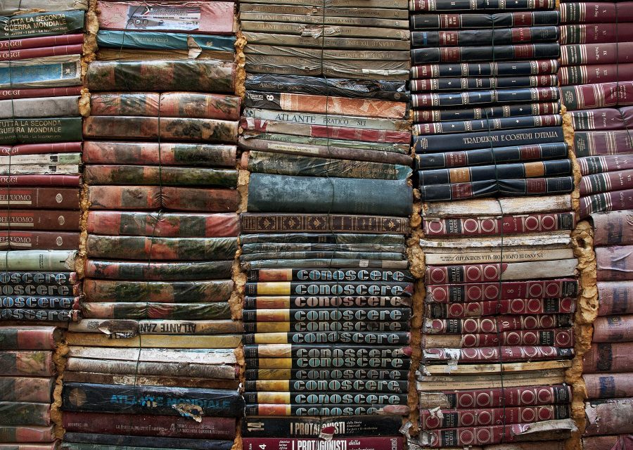Stacks of old cloth- and leather-bound books.
